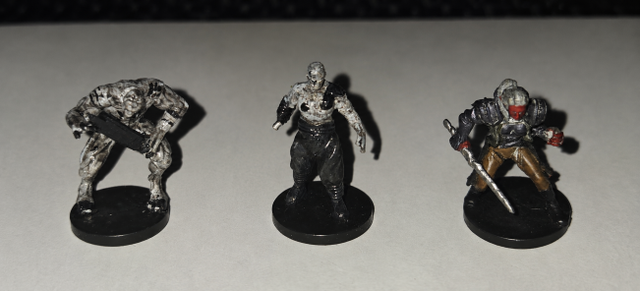 Three Miniature Figures Under Flash Lighting (2).png