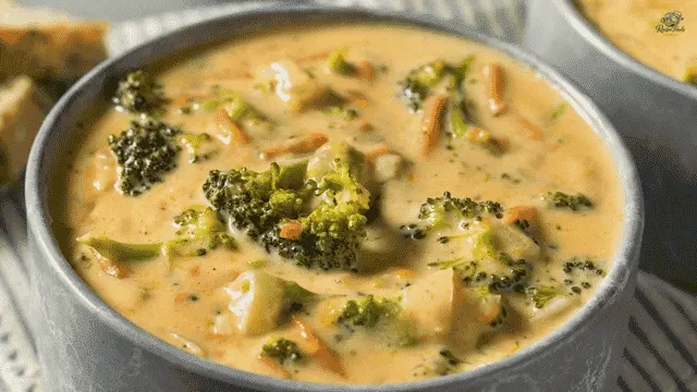 Broccoli Cheddar Soup with Velveeta Cheese Creamy broccoli cheddar soup made with Velveeta cheese, broccoli florets, and carrots served in a grey ceramic bowl.