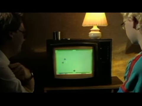 Two people beside a small television showing a game in the home computer segment