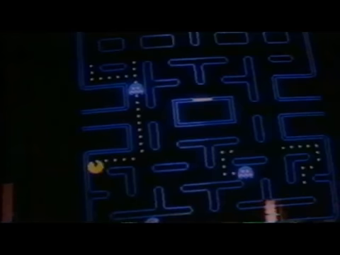 A blue maze with dots and moving characters on an arcade screen