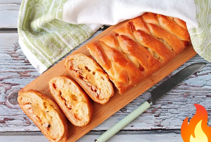 Фото Дрожжевой закрытый пирог-плетёнка с курицей, сыром и томатным соусом