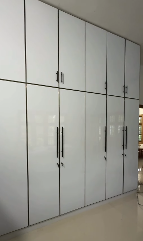 Spacious bedroom wardrobe design with custom shelving by Dream House