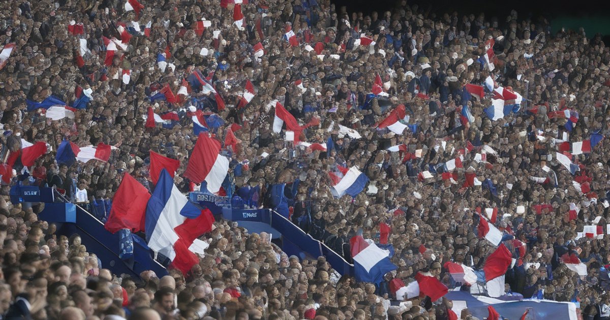 French football captain clutching ankle on pitch while coach watches concerned from touchline during night match