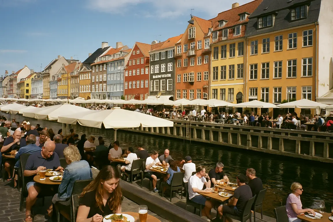 Udendørs restaurant ved Nyhavn med farverige huse og mennesker siddende ved borde.