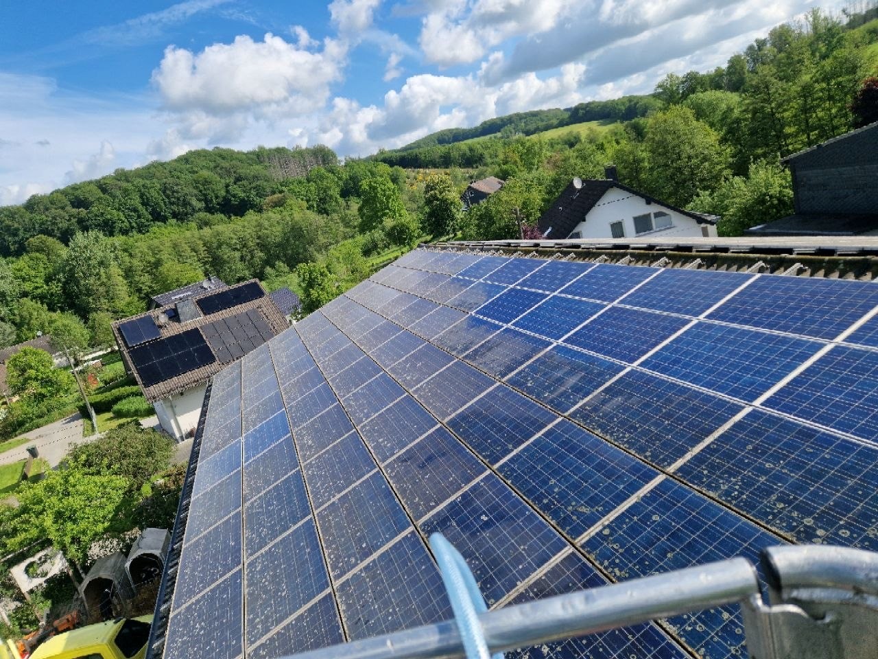 Von der Hubarbeitsbühne: Solarmodule auf Hofdach in Lindlar während der Reinigung – halbseitig gesäubert, Kontrast deutlich erkennbar