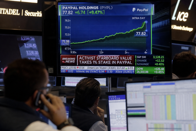 A modern fintech trading floor with analysts watching monitors showing a sharply rising payments stock ticker, financial news documentary st