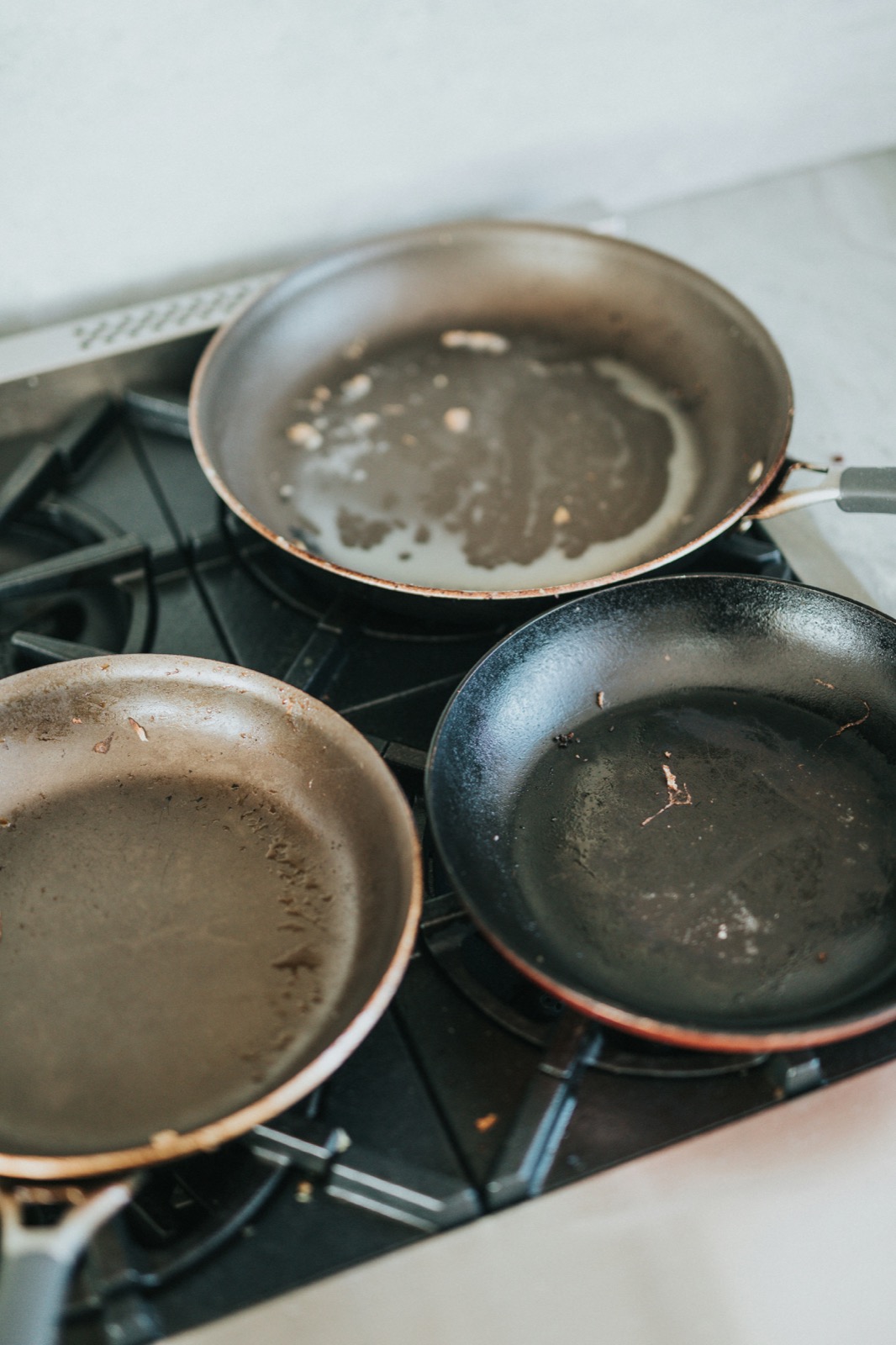 Used pans on a kitchen stove with visible residue