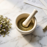 Bacopa monnieri leaves, ground powder, and supplement capsules on a marble surface