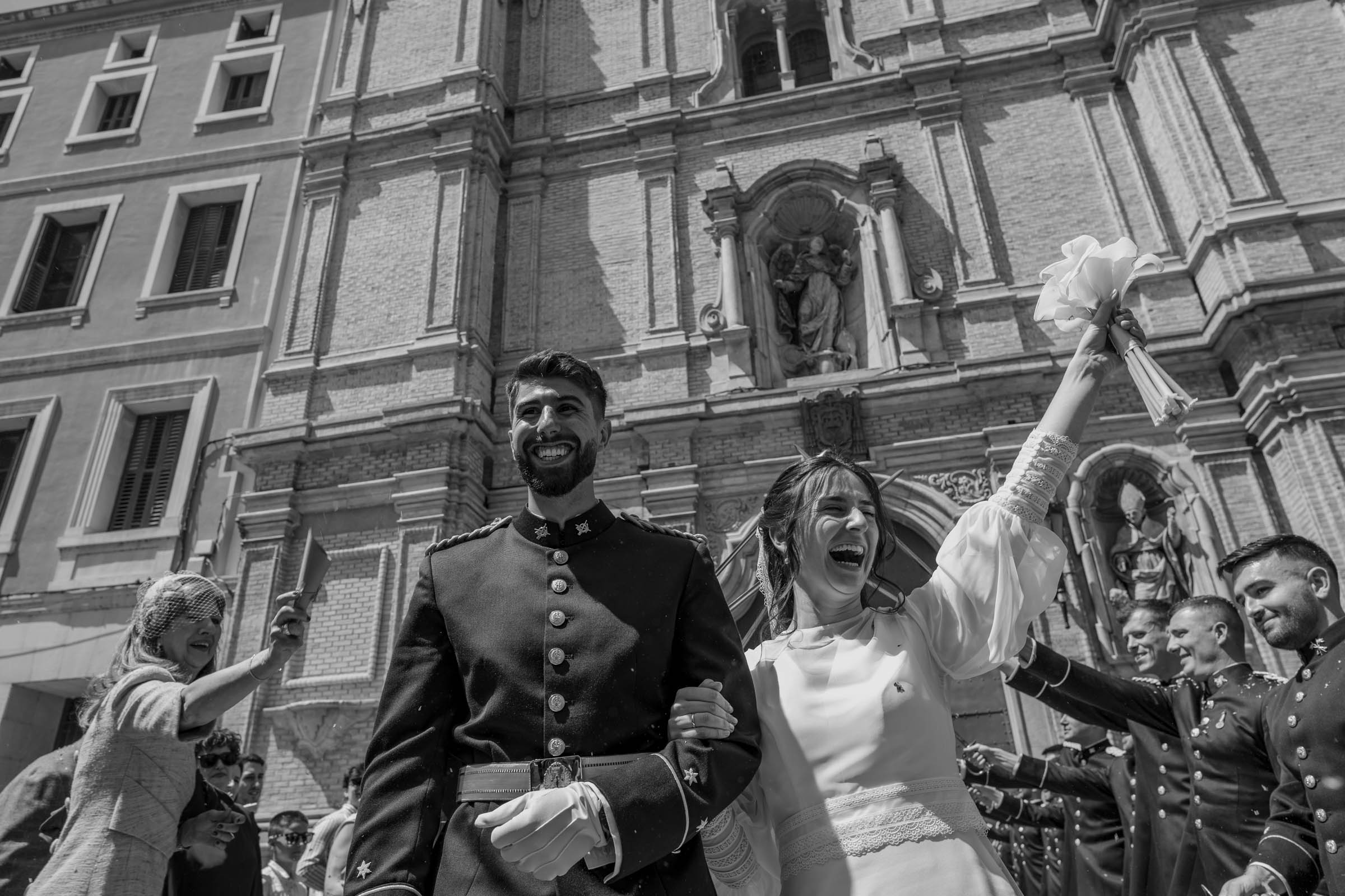 Fotografía de boda en Zaragoza de la salida de los novios de la iglesia rodeados de familiares y amigos