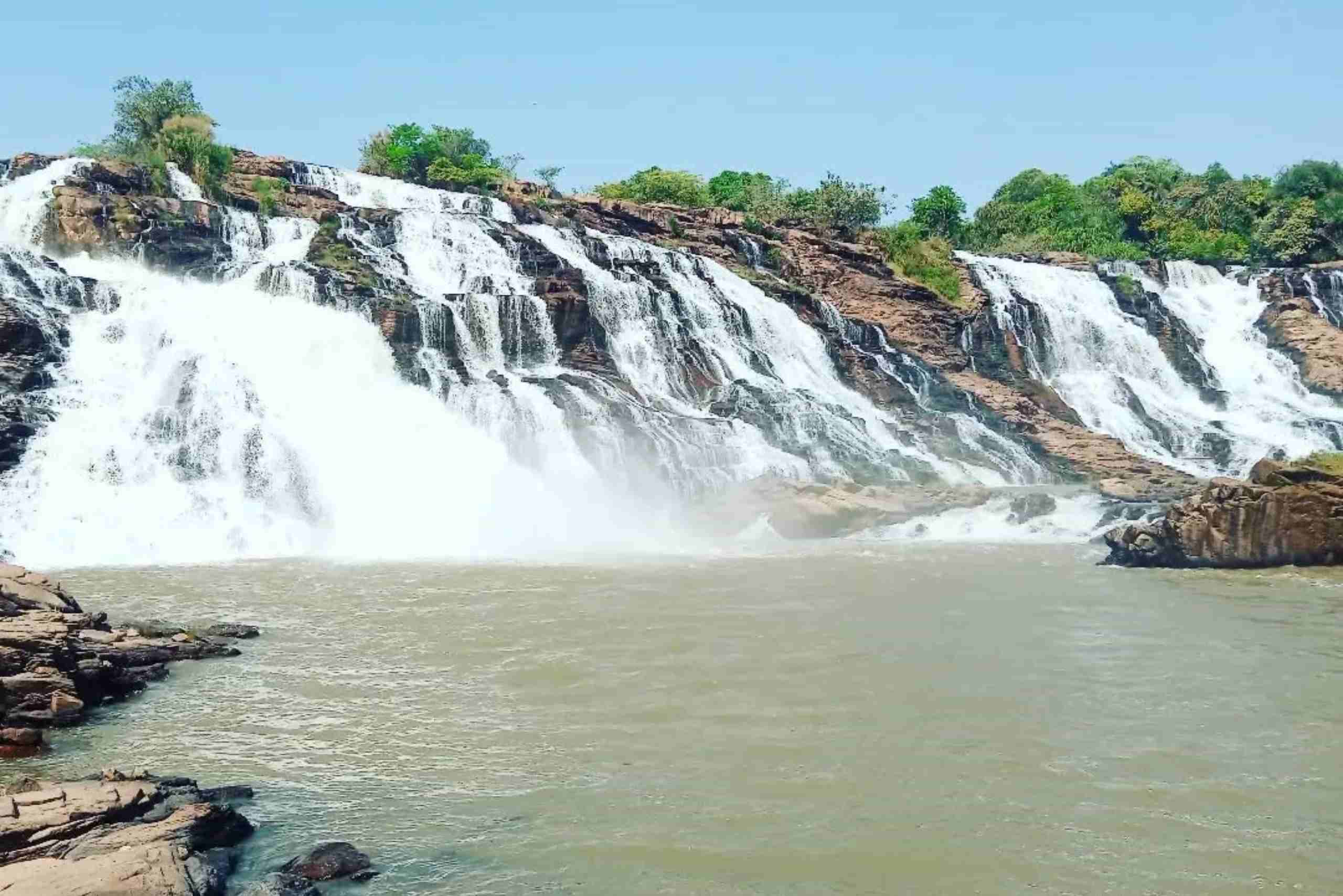 An image showing a cascade of water flowing down the rocky cliffs at Gurara Waterfalls.