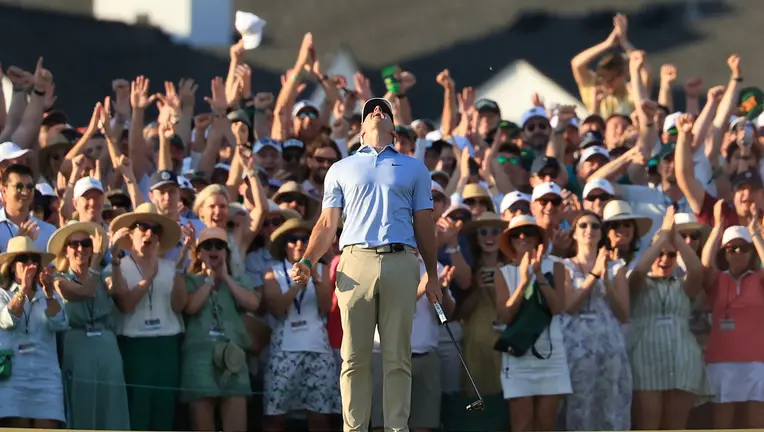 Rory McIlroy holding a golf championship trophy