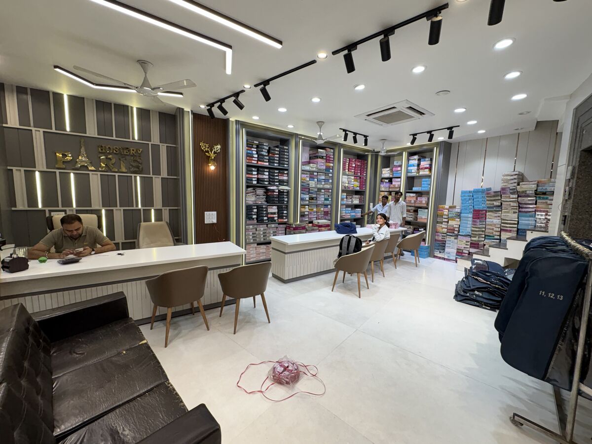 Shop floor with staff and shelves stocked with folded garments