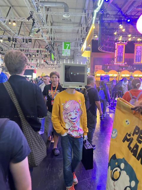 Crowd of attendees in costume moving through the show floor