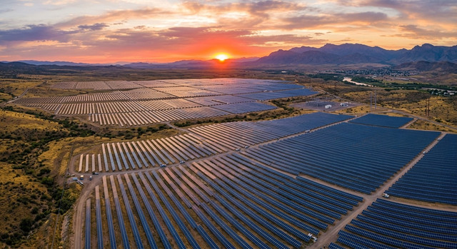 Aerial view of a large-scale solar farm at sunset