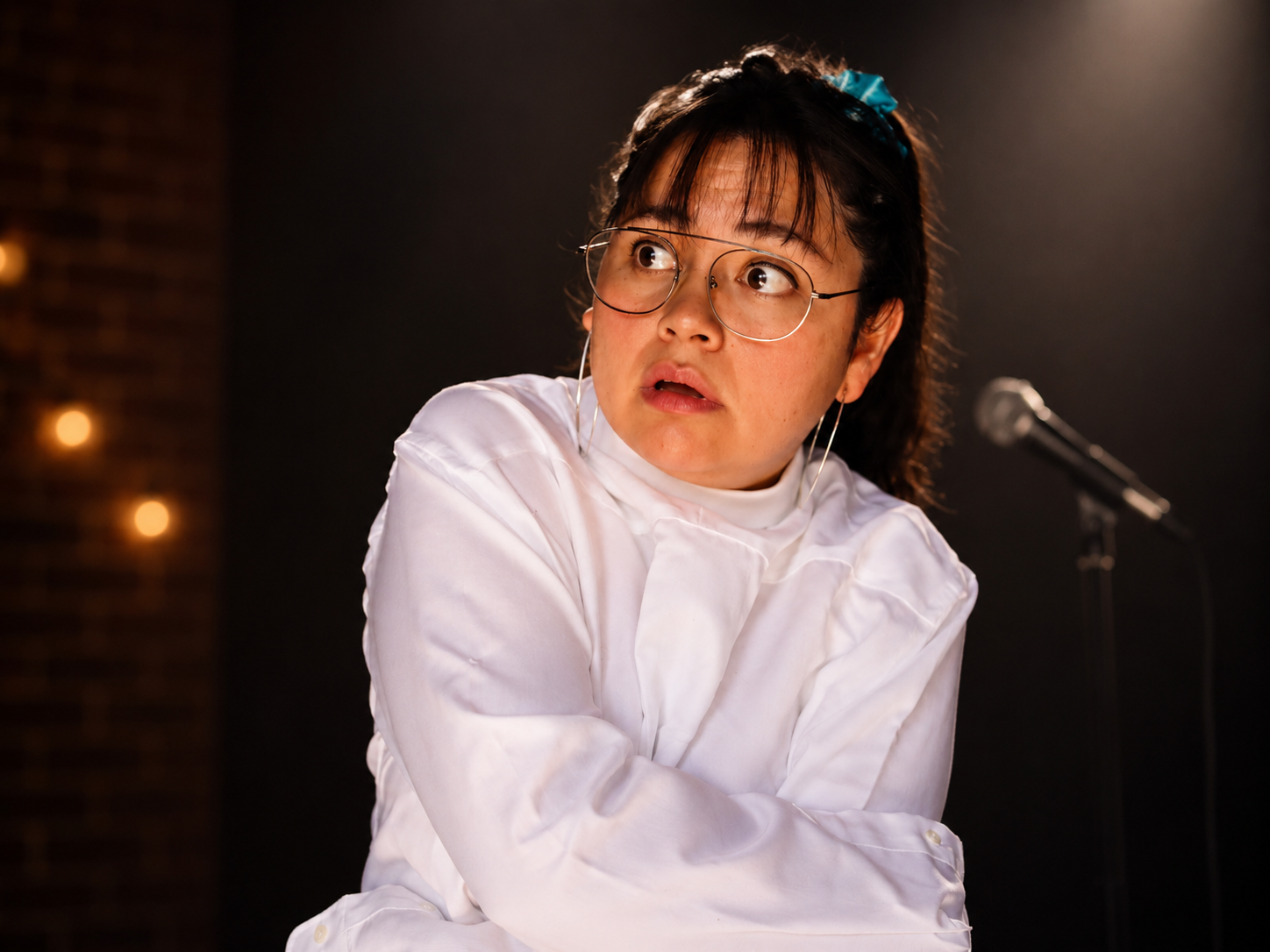 Estrella Marina sonriendo en el escenario con chaqueta de plumas blancas