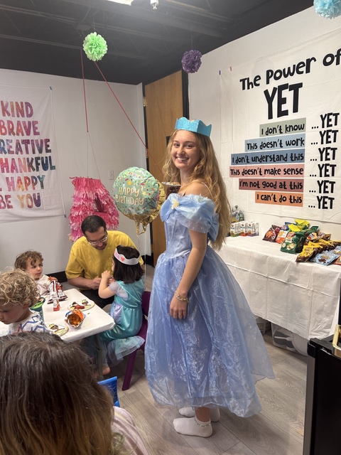 A princess in a blue gown with a balloon at a Yoga@Play birthday party