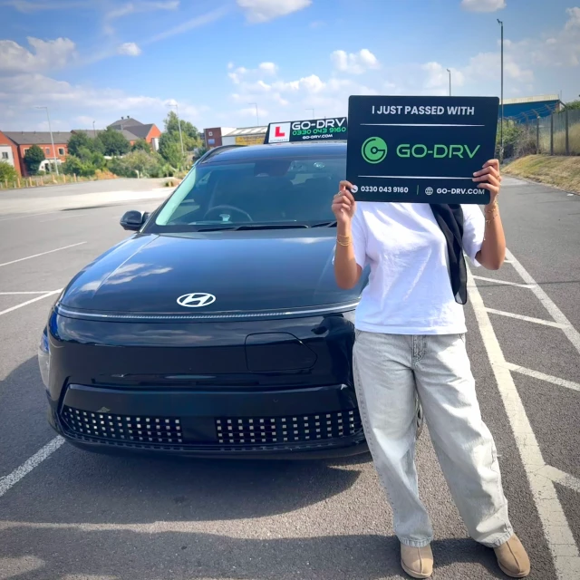 GO-DRV student Saadiya K. holding pass board celebrating 1st time automatic driving test pass in Wolverhampton