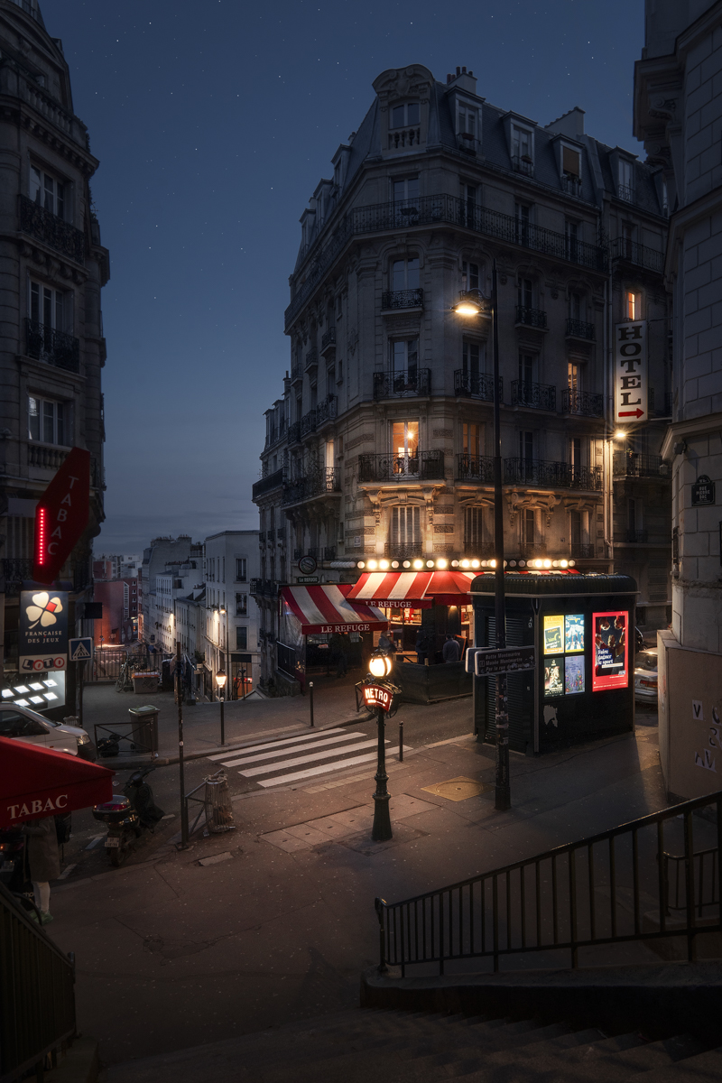 The finished Paris edit — a Paris street corner at blue hour, lit awning and hotel sign