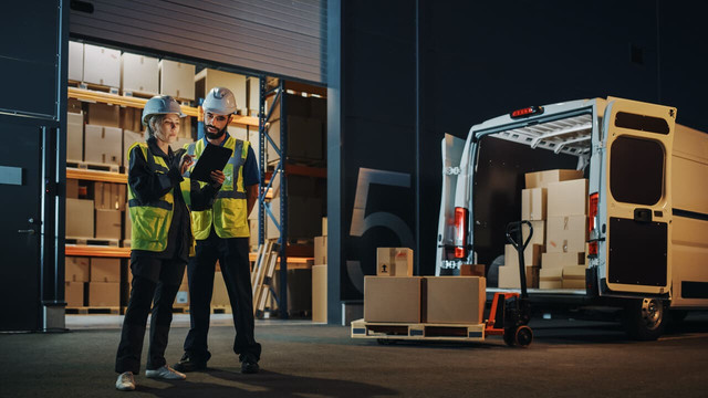 outside logistics distributions warehouse with manager using tablet computer diverse workers loading.jpg
