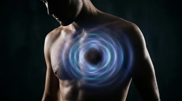 Human torso radiating glowing electromagnetic field from heart area in dramatic lighting