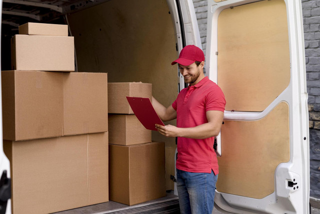 high angle delivery man checking packages list.jpg