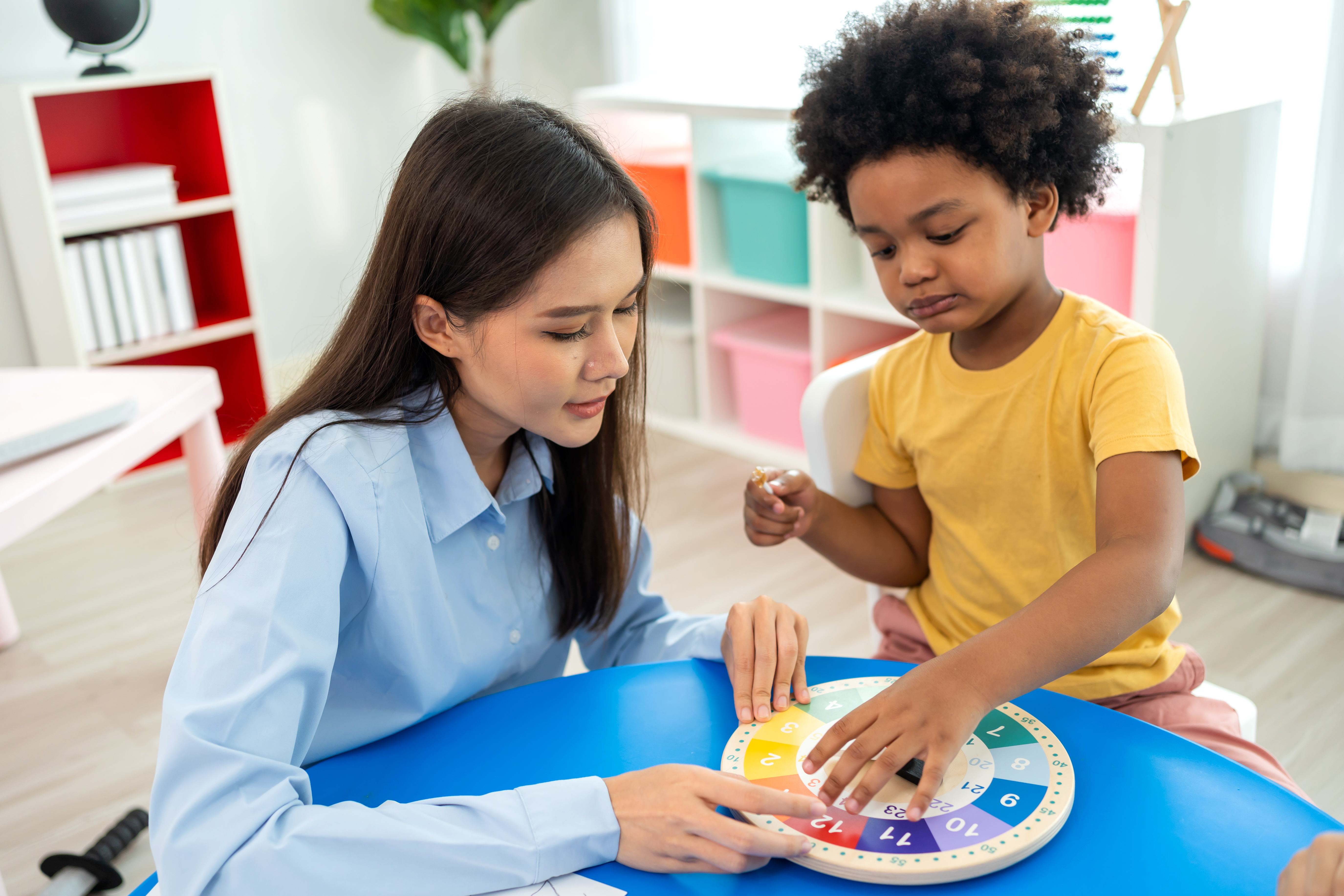 A preschool teacher with children in a classroom.