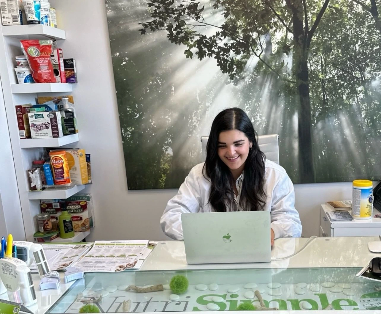 Nutritionniste utilisant un ordinateur et des aliments frais pour expliquer des recommandations nutritionnelles personnalisées.