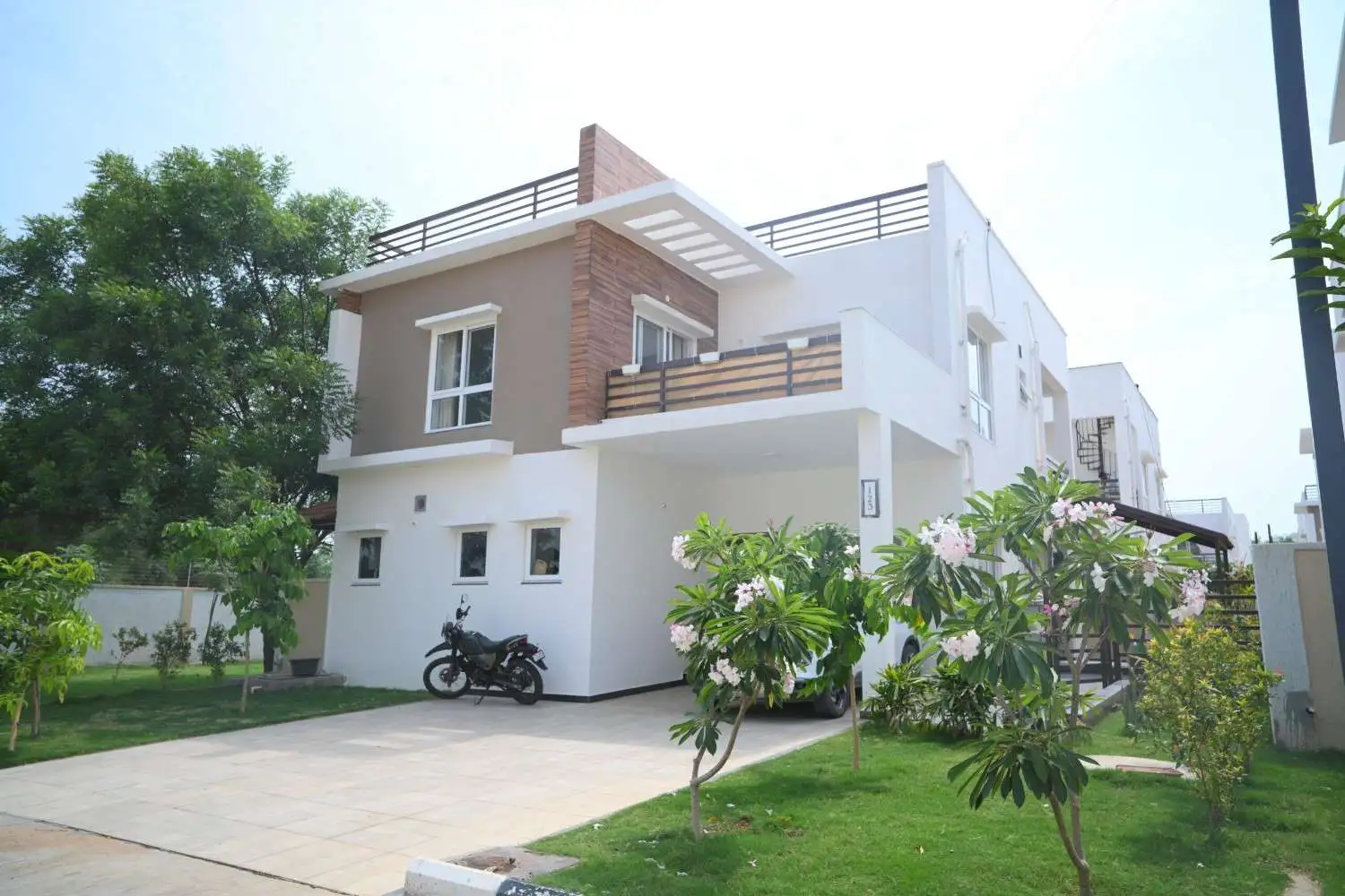 Aerial view of a gated community villa layout with clubhouse and green spaces in Mokila