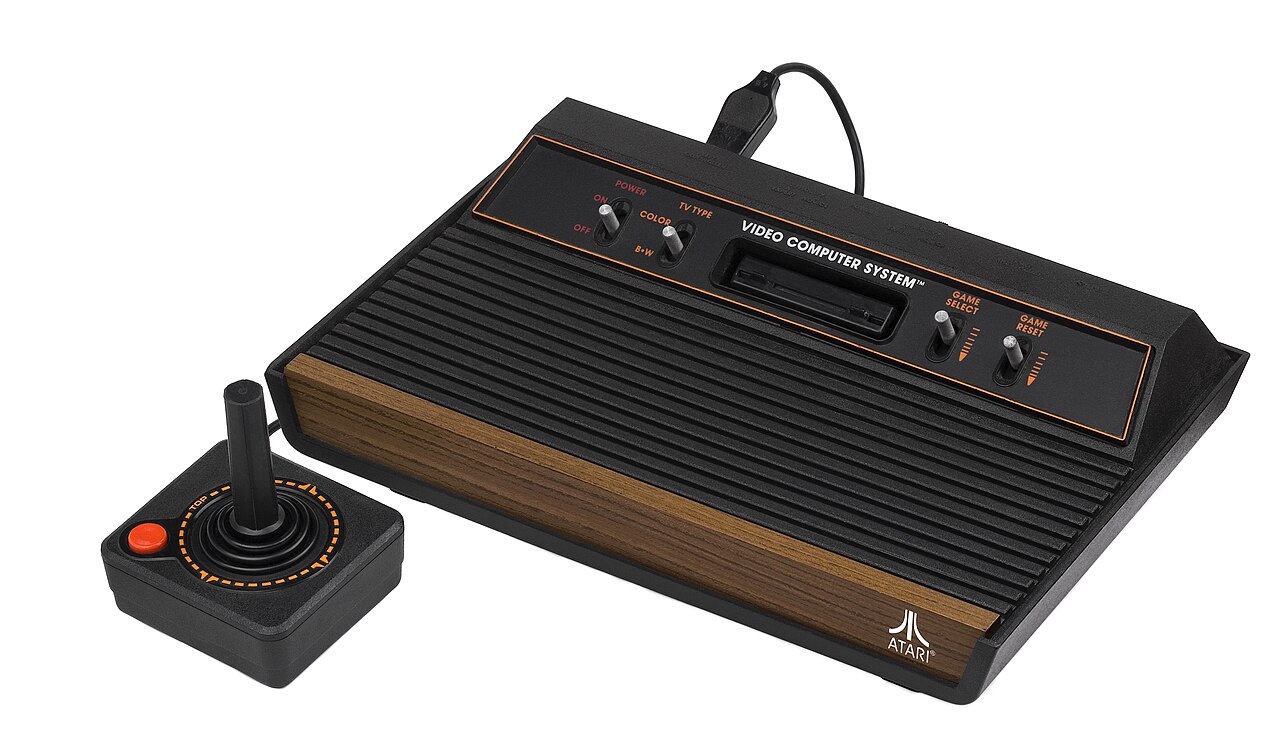 A four-switch Atari 2600 console with a wood-effect front and its joystick