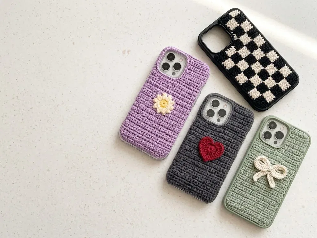 Crochet phone case collection showing four finished shell-cover designs together in one scene