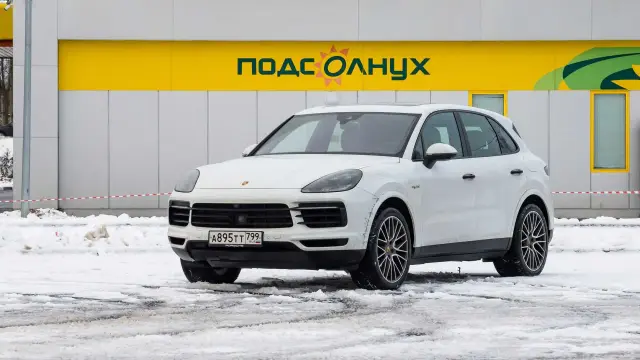 Автор: Ману Чаподзе
Российский офис Porsche живет по собственным законам, не подчиняющимся никакой базовой логике. Вдумайтесь: пока весь мир страдает от пандемии, а большинство брендов кручинится из-за просадки продаж, дилеры штутгартского производителя не знают, как обеспечить машинами всех желающих. В преддверии нового года клиенты марки опустошили все шоу-румы: уютное место в очереди за кроссовером Cayenne из ближайших партий перепродают по миллиону рублей.

Объяснить популярность «Кайена» у состоятельной публики несложно: в мире не так много автомобилей, способных столь же умело сочетать повадки спорткара с возможностями серьезного внедорожника. Не считая бодрящего ценника, это машина без выраженных слабых мест. А еще даже после отказа Porsche от дизельных двигаталей, «Кай» предлагает немало вариантов: от начальной 340-сильной «турбошестерки» до неистовой 680-сильной версии Turbo S E-Hybrid.

Сегодня речь также пойдет о гибриде. Однако для теста на экономичность была выбрана более приземленная модификация E-Hybrid. Наддувный V6 обычного «Кайена» дополнен стокиловаттным электромотором и тяговой батареей емкостью 14,1 кВтч с возможностью зарядки от внешней сети. Такой кроссовер обещает набирать сотню за пять секунд ровно и потреблять в смешанном цикле 3,4 литра бензина, оказываясь самым экономичным в линейке. Проверим на деле.

Старт – с АЗС сети «Роснефть» на Минской улице. Заправляем Cayenne топливом Pulsar 100 «под пробку» (использовать АИ-95 изготовитель рекомендует лишь в крайних случаях), проверяем давление в разношироких шинах Pirelli Scorpion Winter и выдвигаемся в сторону трассы M-11. Наш эксперимент предполагает бросок до Твери по участку питерского «платника» и возращение домой по бесплатной M-10. На все про все – 370 км (подробнее о методике испытаний – в дебютном материале).