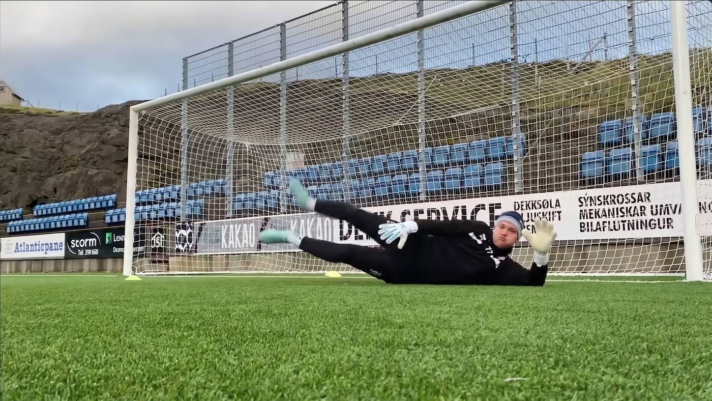 Goalkeeper diving low to his right across the goal during a diving-focused session