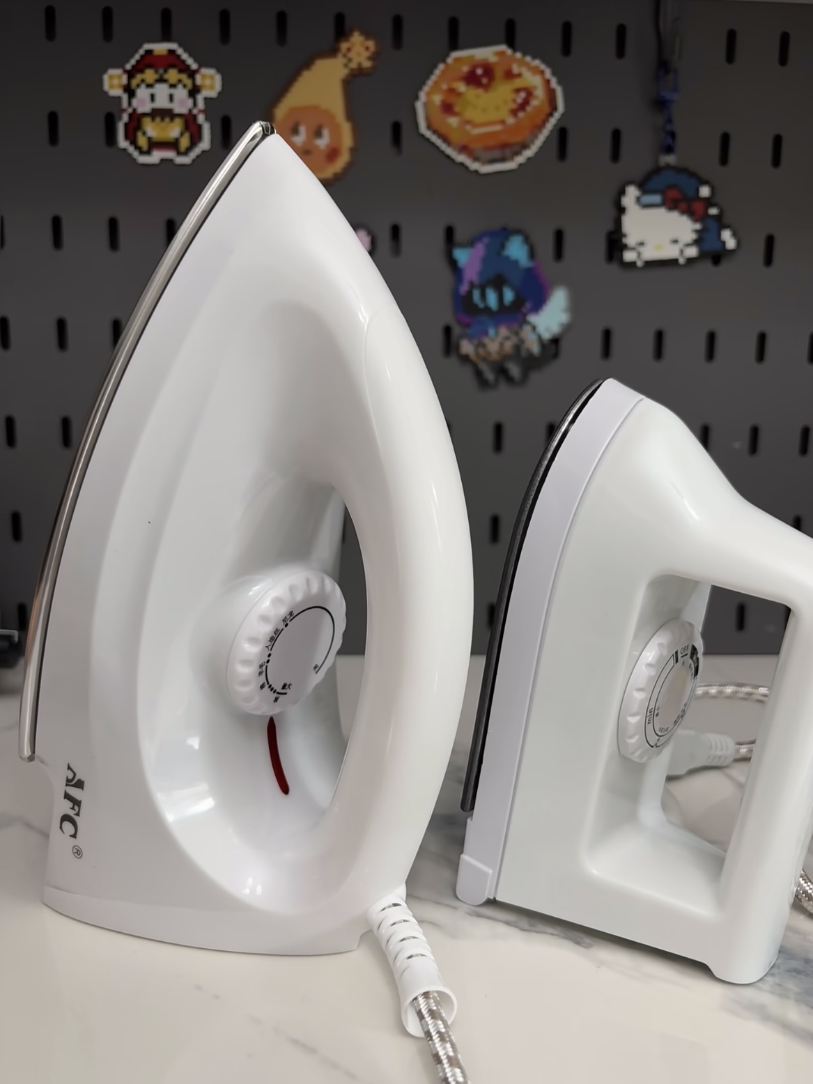 A standard household clothes iron next to a tiny, low-heat toy iron from a cheap Perler bead kit
