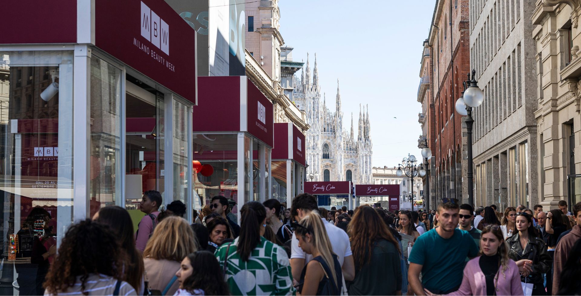 Milano Beauty Week, i Beauty Cube nel centro di Milano I Beauty Cube di Milano Beauty Week lungo una strada affollata con il Duomo sullo sfondo