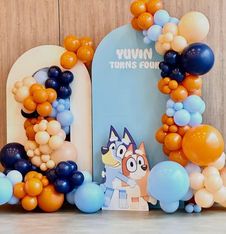 Bluey themed Yuvin Turns Four birthday backdrop with blue and orange balloons