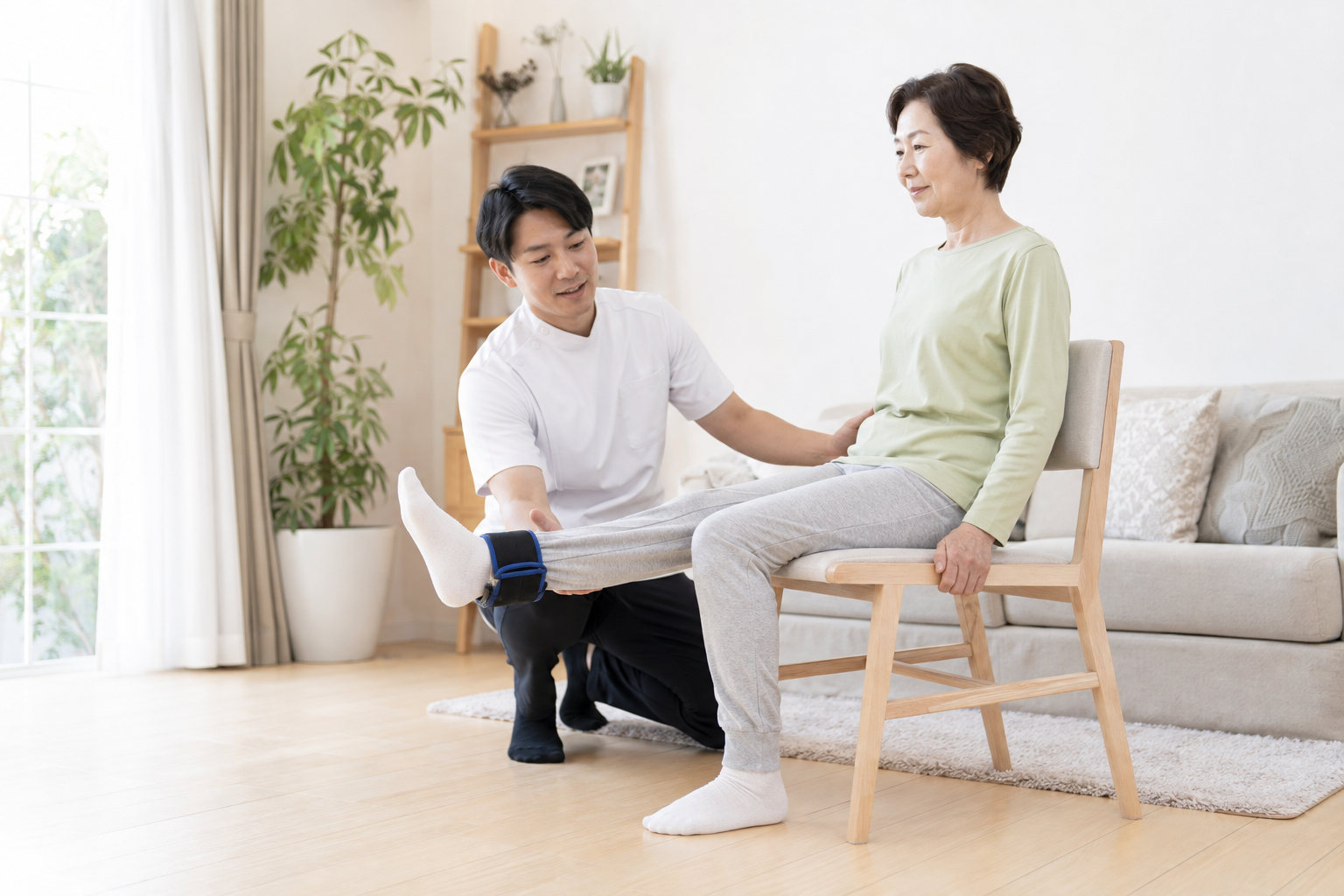 変形性膝関節症の人が椅子で膝伸展の筋力トレーニングを行う場面