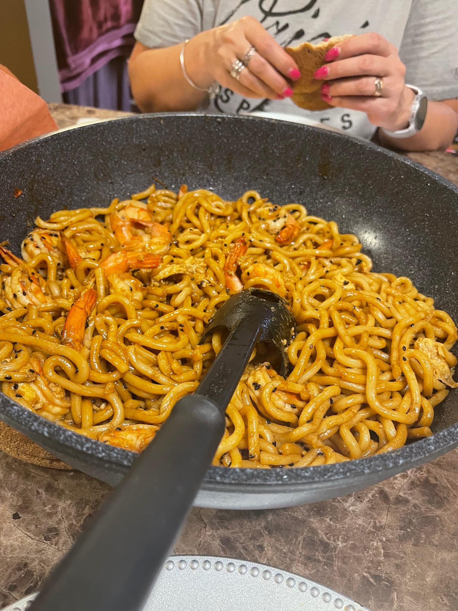 A giant wok of udon noodles with shrimp.