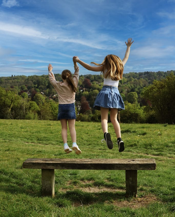 Two girls jumping together