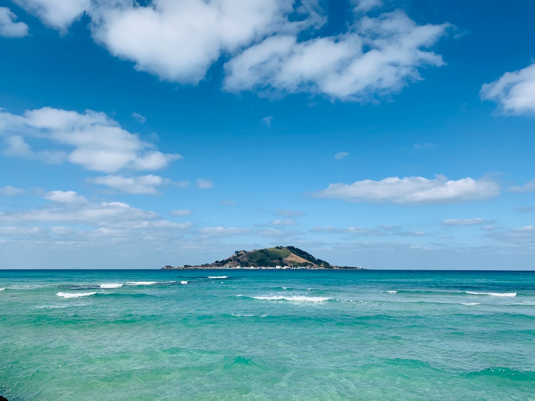 Seobin Baeksa coral sand beach Udo Island with turquoise water and Seongsan Ilchulbong in background