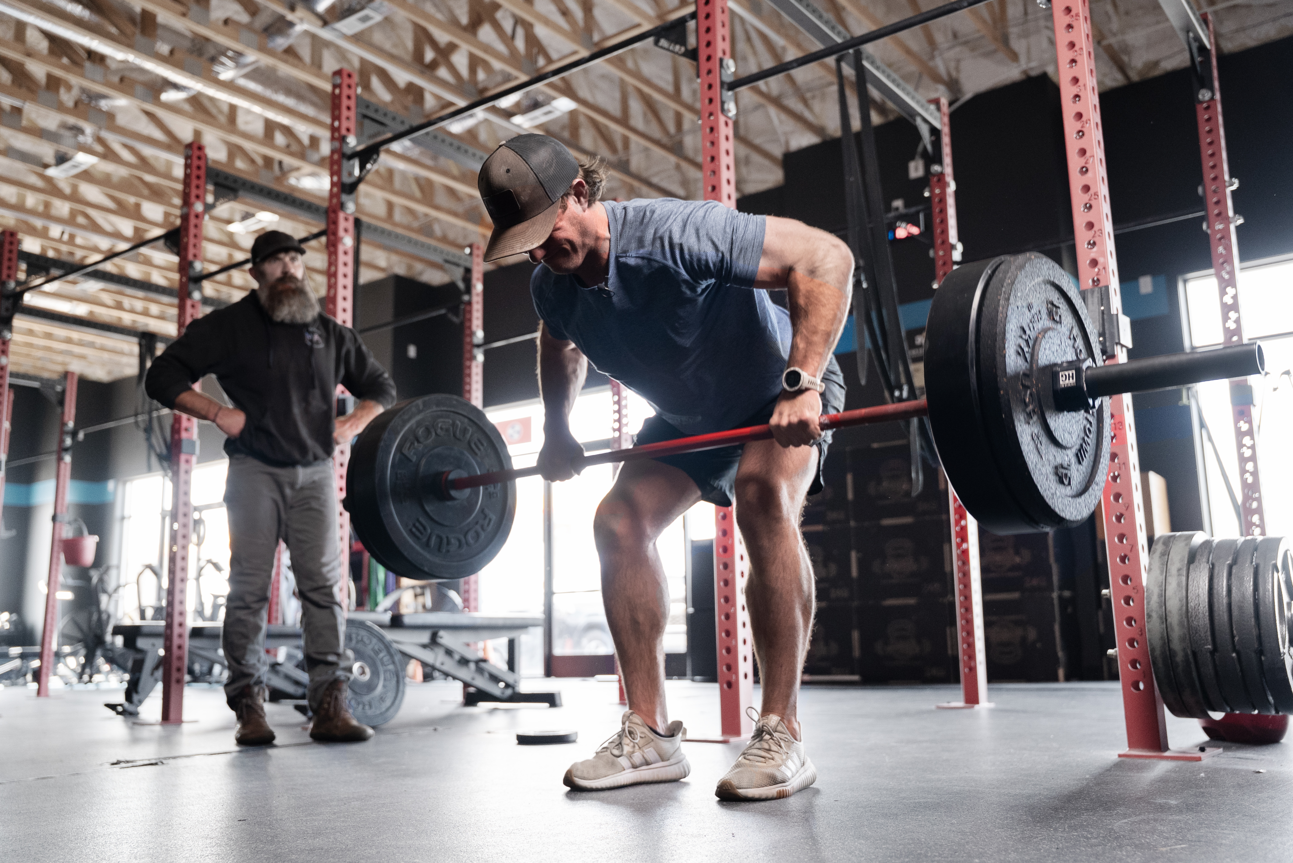 Coach instructing athlete on barbell lift