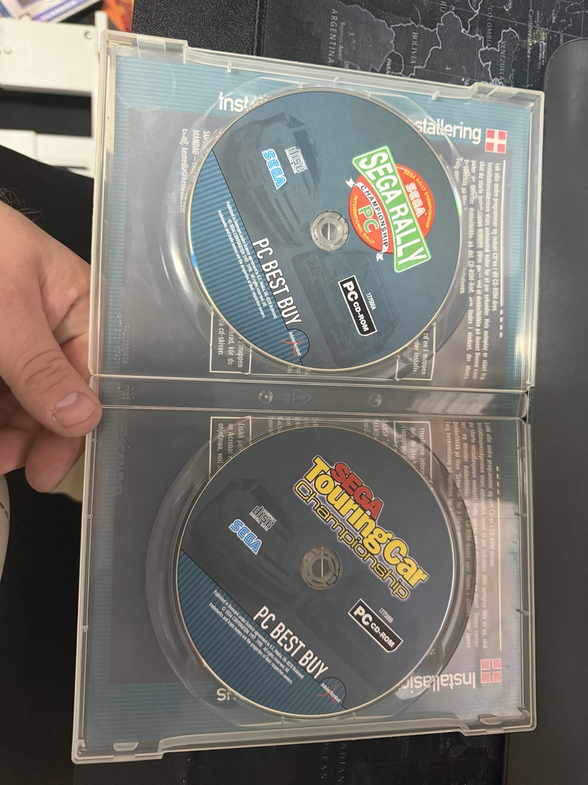 Both Sega CDs and instructions visible through the clear case