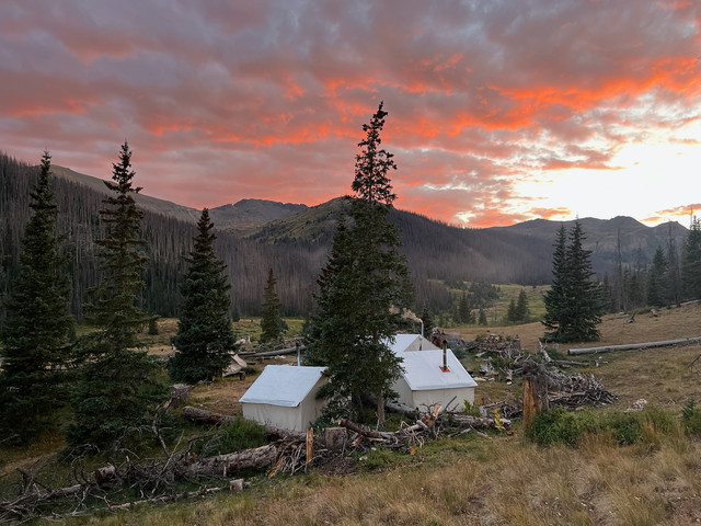 Wall tents at backcountry camp with Colorado mountain sunset