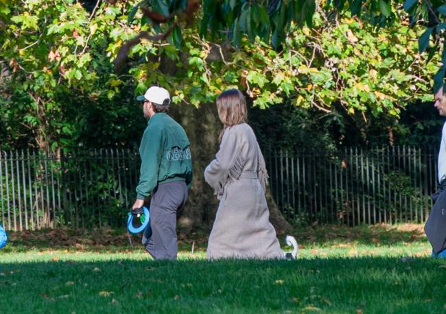 Woolley llevaba un suéter color canela sobre su ropa informal mientras sostenía la correa del perro mientras caminaba por el parque cubierto de césped.MJ-Pictures.com / SplashNews.com