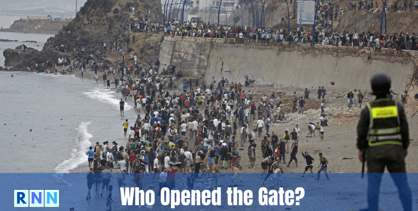 Migrants crossing a border fence near Ceuta