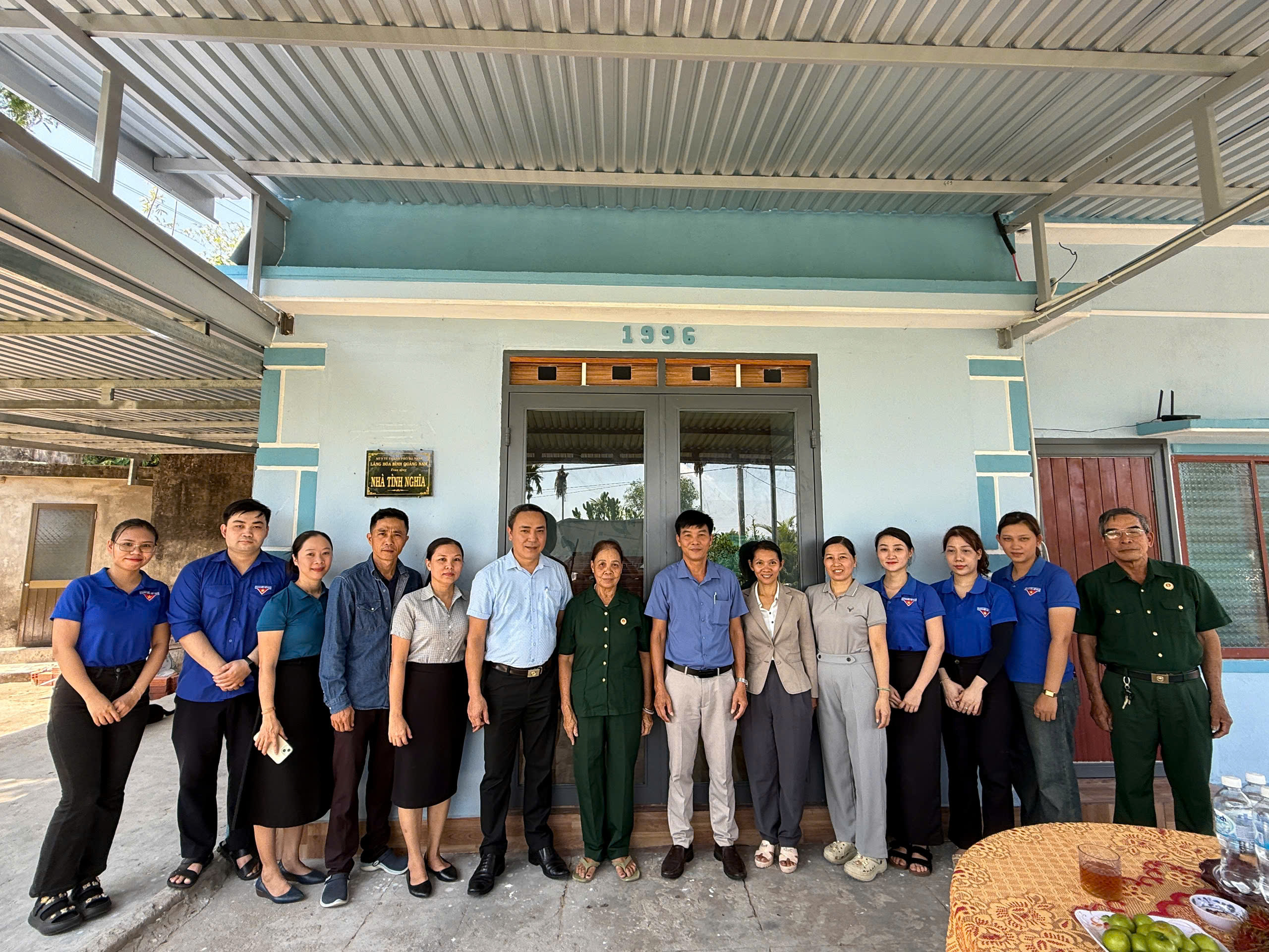 Đại biểu, lãnh đạo Làng Hòa Bình Quảng Nam cùng viên chức, người lao động và gia đình bà Đinh Thị Mai Loan chụp ảnh lưu niệm tại ngôi nhà tình nghĩa.
