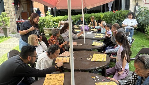 Pasantes de la ONG Huellas coordinando una gran jornada de juegos grupales con abuelos en un jard&iacute;n geri&aacute;trico
