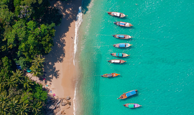 Aerial view of a tropical island in Thailand showcasing turquoise waters, white sand beaches, and lush greenery — highlighting why Thailand is the perfect destination for property investment with Propuno in 2025.