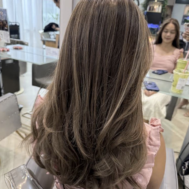 Long layered brunette hair with soft highlights styled at Olson Studio