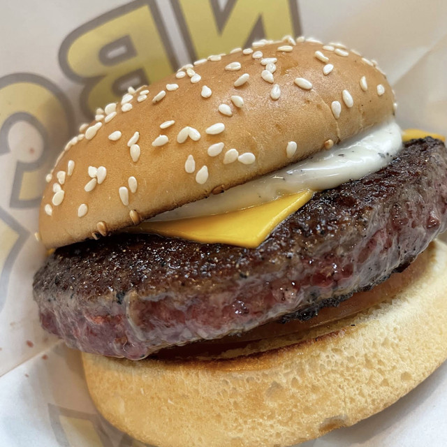 Close-up of a NBCB beef cheeseburger with melted cheese