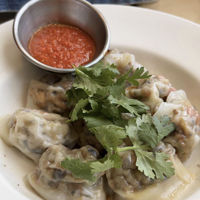 Handmade vegetarian dumplings served with a dipping sauce at Real Food